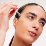 Нанасяне на серум от серията Skin Drop MOOKAJÉ с пипета върху кожата на лицето